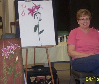 Woman with a painting of a stargazer lily.